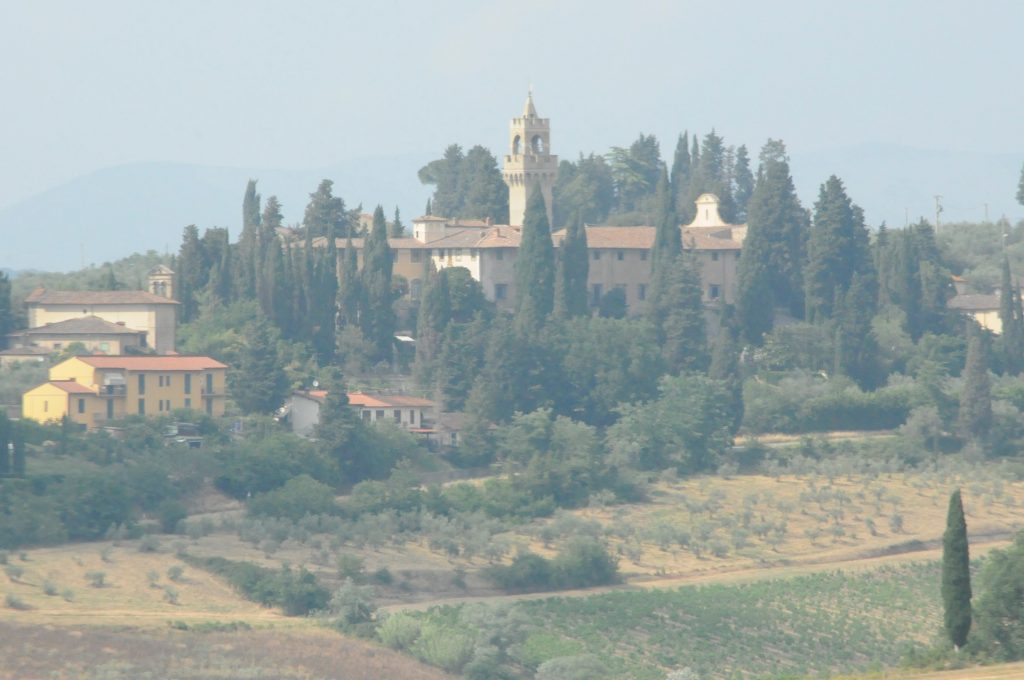 Misty photo of a Renaissance villa on a Tuscan hillside, surrounded by Cypress trees