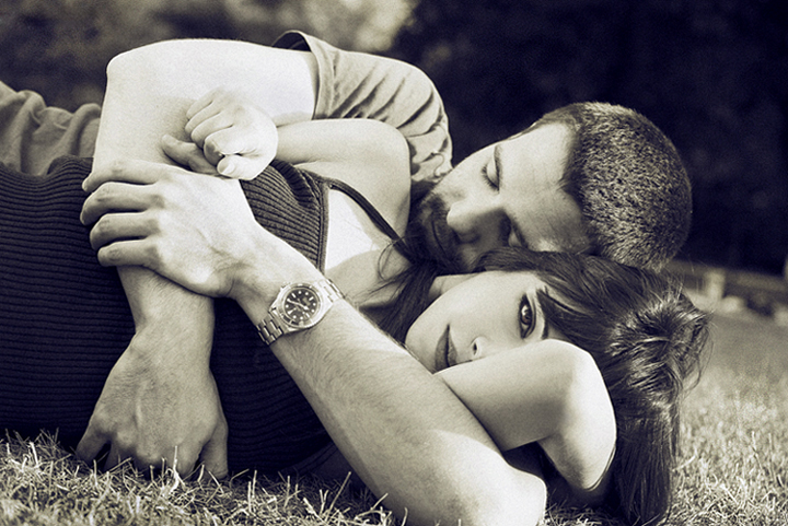 man embracing woman who looks out at camera (detached?)